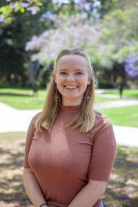 Photo of Erika Snell, wearing a brown shirt in an outdoor setting.