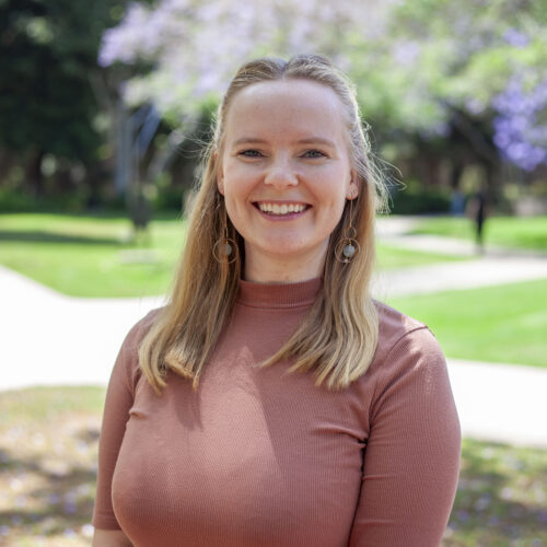 Photo of Erika Snell, wearing a brown shirt in an outdoor setting.