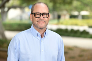 Photo of Thomas Garbelotti, wearing a light blue shirt in an outdoor setting.