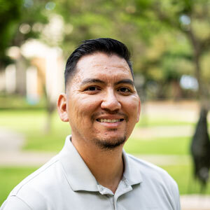 Photo of Luis Martinez in a white shirt in an outdoor setting.