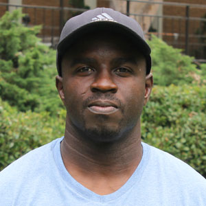 Picture of Shawn Higgins in a light blue shirt and baseball hat outside.